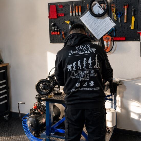 Técnico de E-Planet Mobility reparando un patinete eléctrico sobre una mesa elevadora en nuestro taller de Sevilla.
