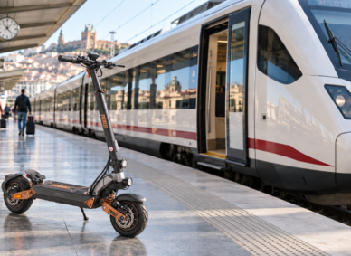 Patinete eléctrico junto a un tren de Renfe