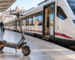Patinete eléctrico junto a un tren de Renfe